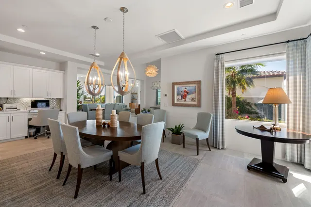 a kitchen with a stove a sink and chairs