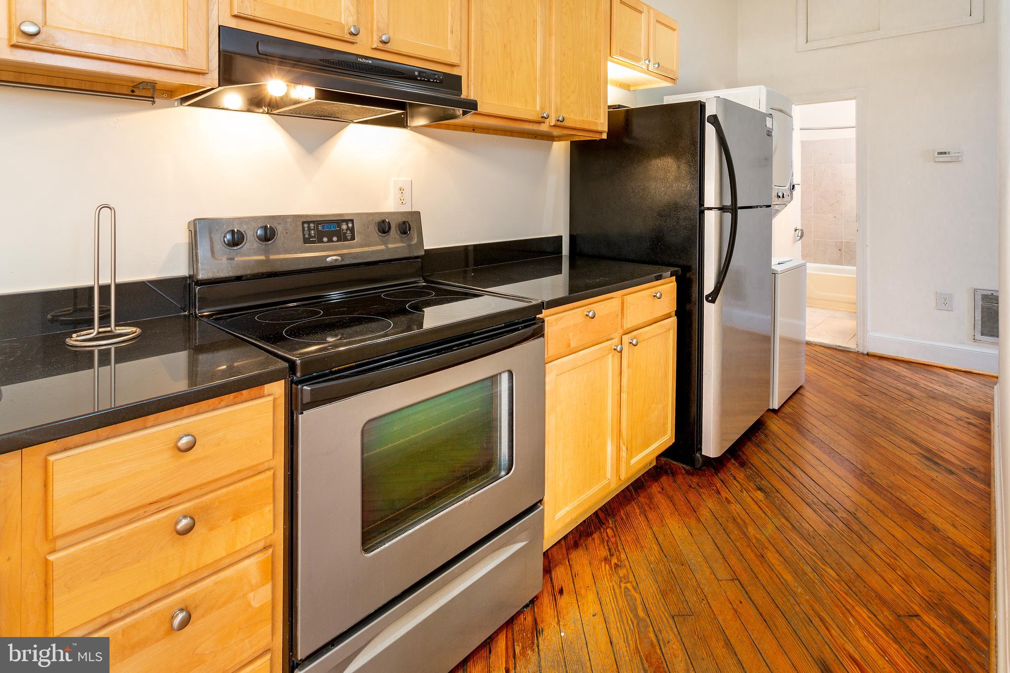 1213 12th Street Northwest, Unit A Washington, DC 20005 - Photo 11 of 25 a kitchen with granite countertop a stove and a microwave