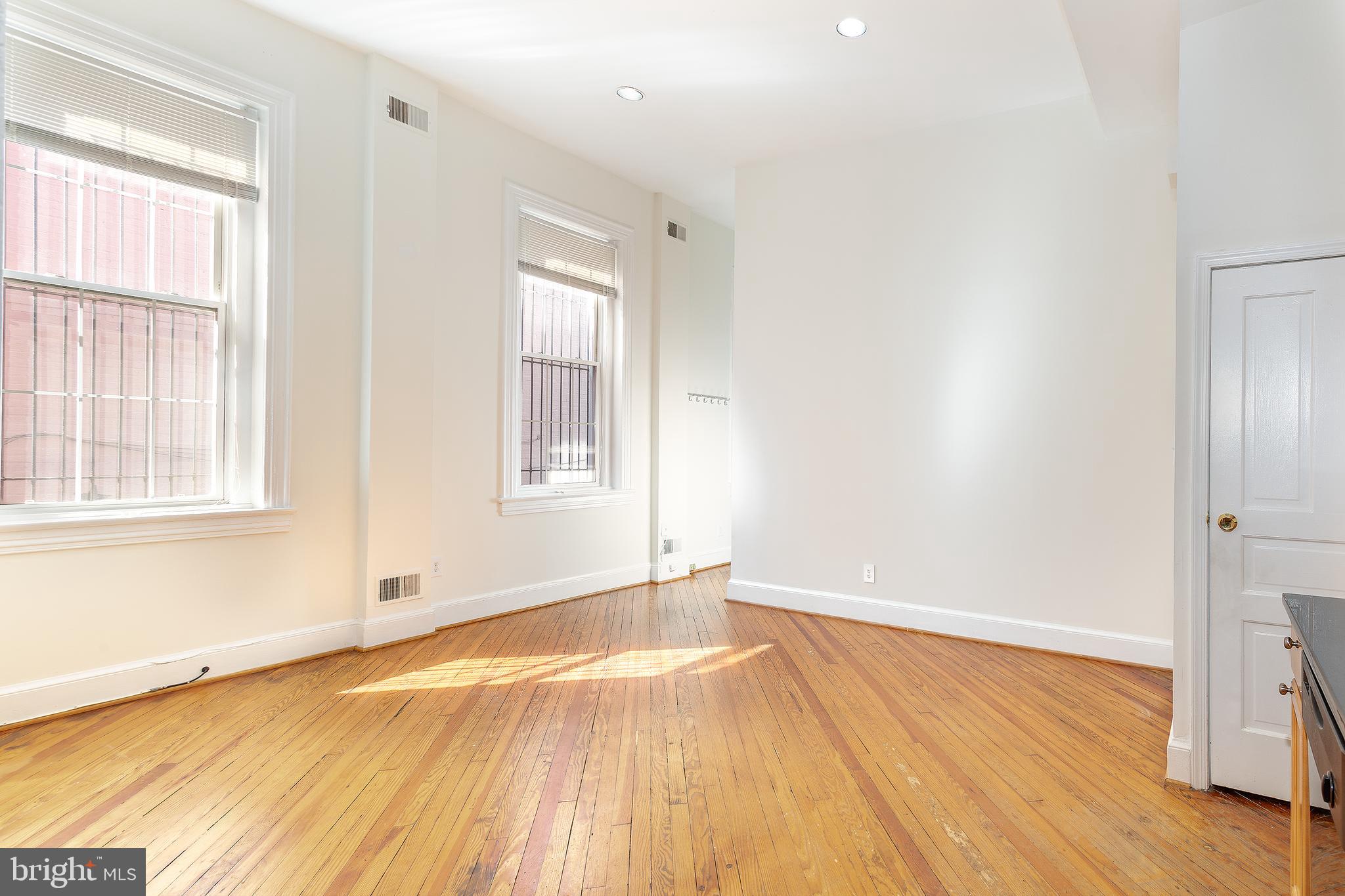 1213 12th Street Northwest, Unit A Washington, DC 20005 - Photo 18 of 25 an empty room with wooden floor and windows
