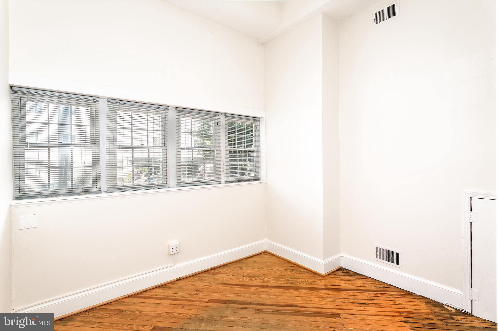 1213 12th Street Northwest, Unit A Washington, DC 20005 - Photo 7 of 25 a view of an empty room with wooden floor and a window
