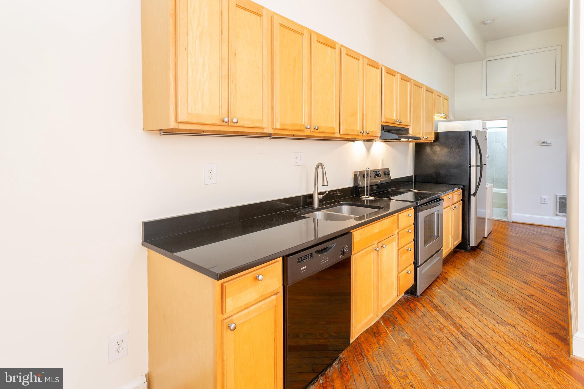 1213 12th Street Northwest, Unit A Washington, DC 20005 - Photo 10 of 25 a kitchen with stainless steel appliances granite countertop a sink a stove and a refrigerator