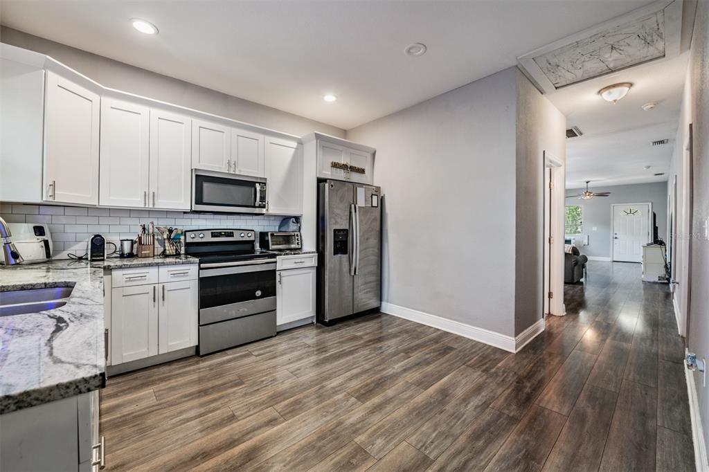 2334 West Spruce Street Tampa, FL 33607 - Photo 12 of 24 a kitchen with granite countertop a refrigerator and a stove top oven