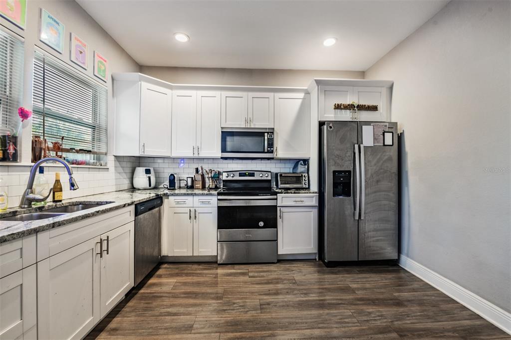 2334 West Spruce Street Tampa, FL 33607 - Photo 13 of 24 a kitchen with stainless steel appliances granite countertop a refrigerator and a stove top oven