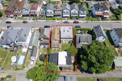 an aerial view of residential houses with outdoor space and parking