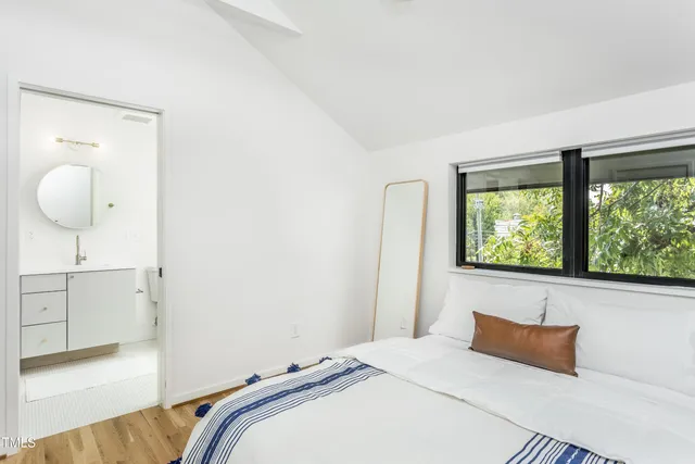 a bedroom with a bed and a large window