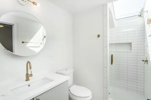 a bathroom with a sink a toilet and shower