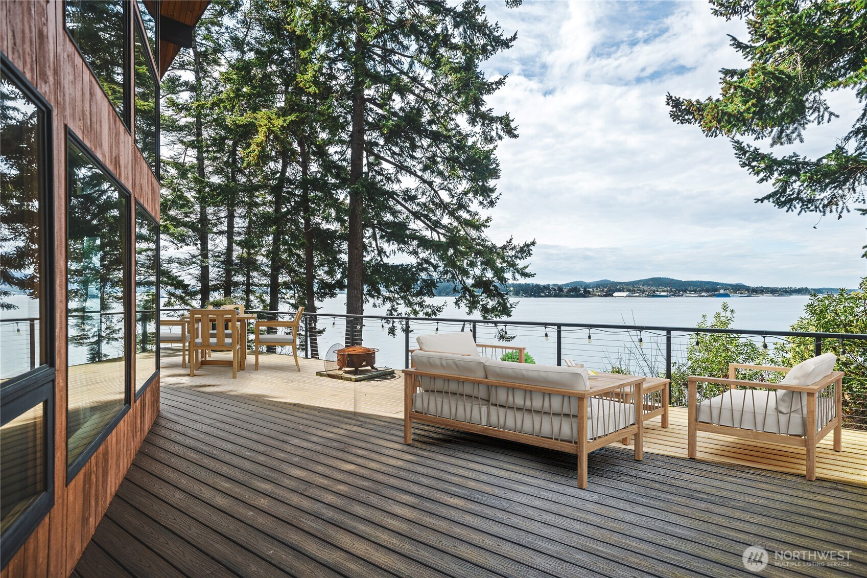7616 Cypress Way Anacortes, WA 98221 - Photo 6 of 35 a view of a balcony with wooden floor and bench next to a road