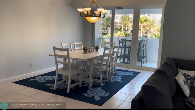 a view of a dining room with furniture a chandelier and wooden floor