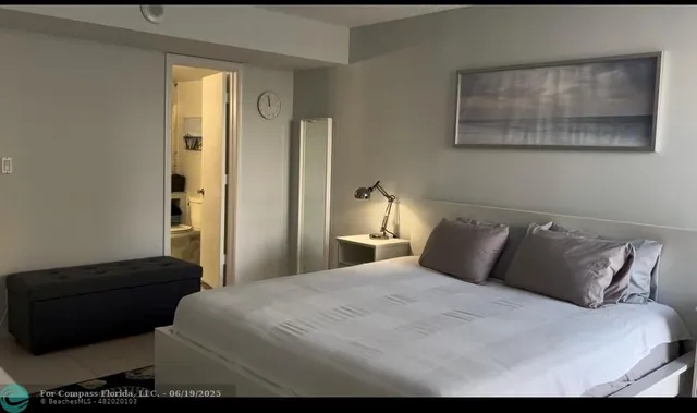 a bedroom with a bed and a painting on the wall