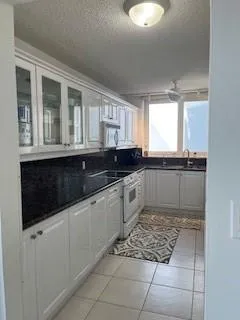 a kitchen with granite countertop a sink and a stove