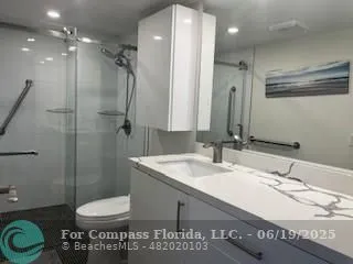 a bathroom with a sink a toilet and shower