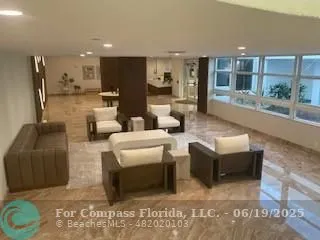 a living room with couches and kitchen view