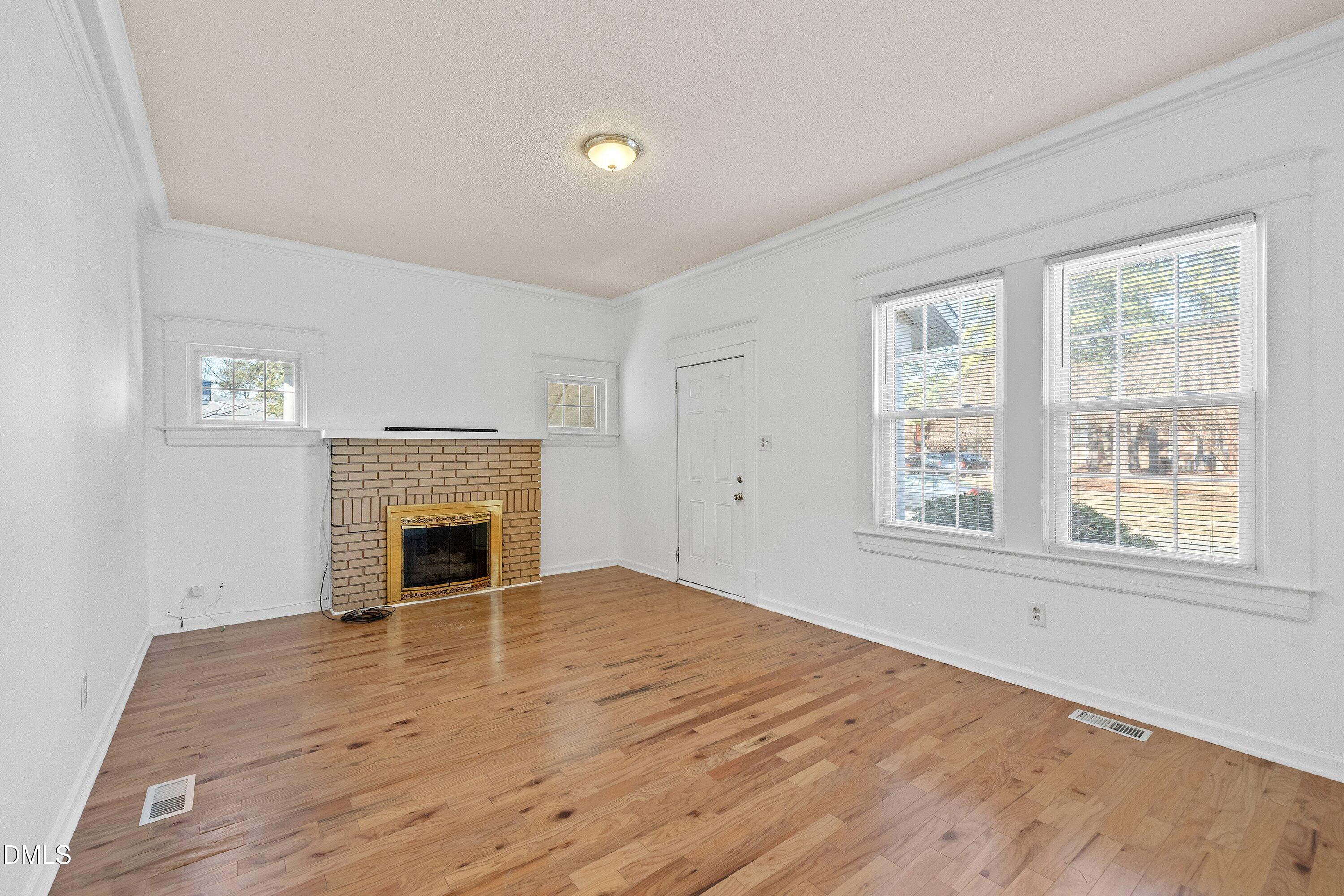 3010 Burrell Place Raleigh, NC 27607 - Photo 16 of 46 a view of empty room with wooden floor and fireplace