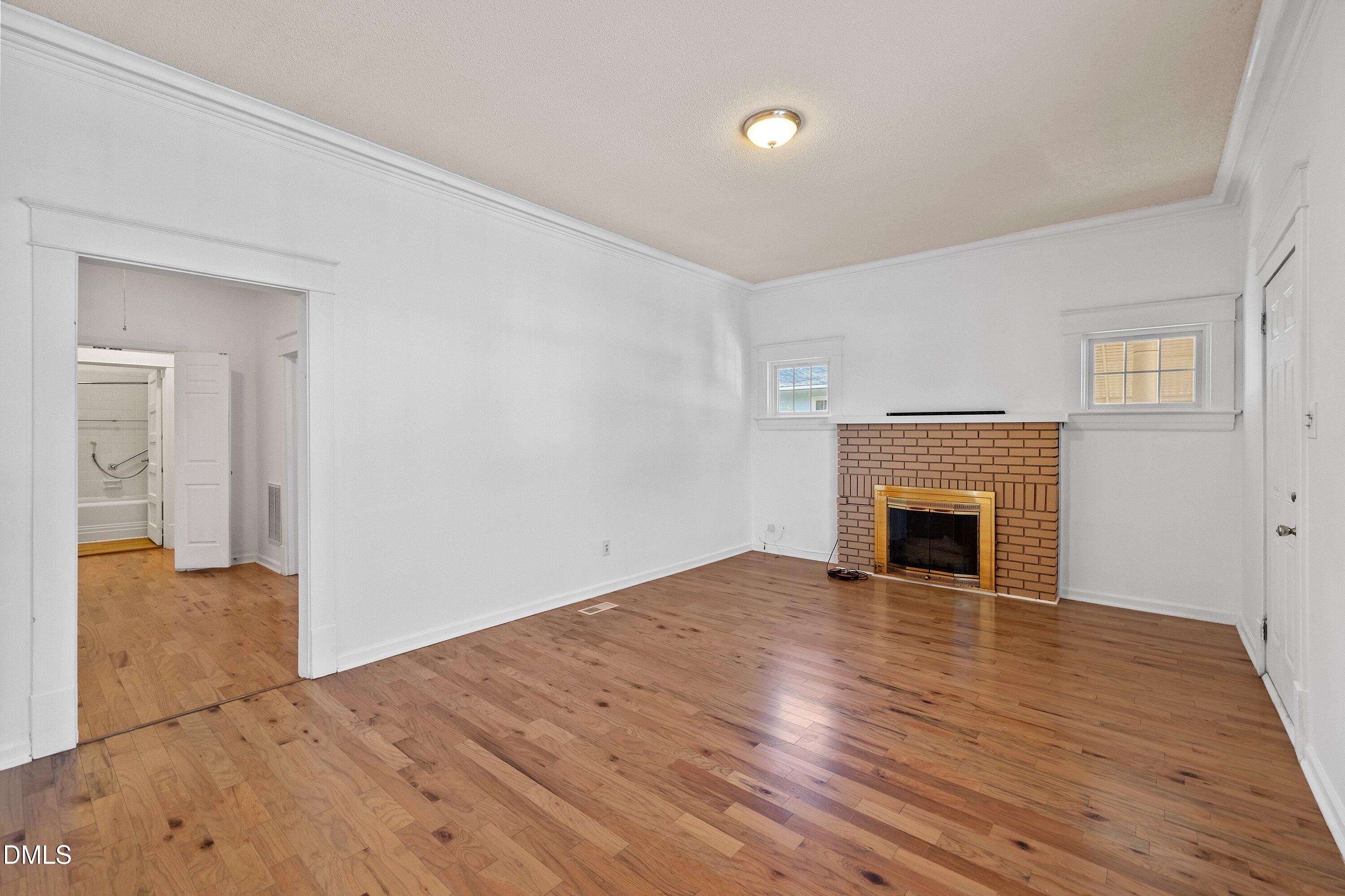 3010 Burrell Place Raleigh, NC 27607 - Photo 17 of 46 a view of empty room with wooden floor and fireplace