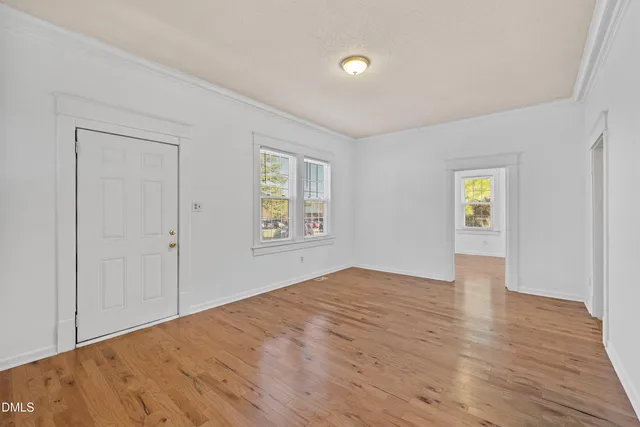 a view of a room with wooden floor and chandelier