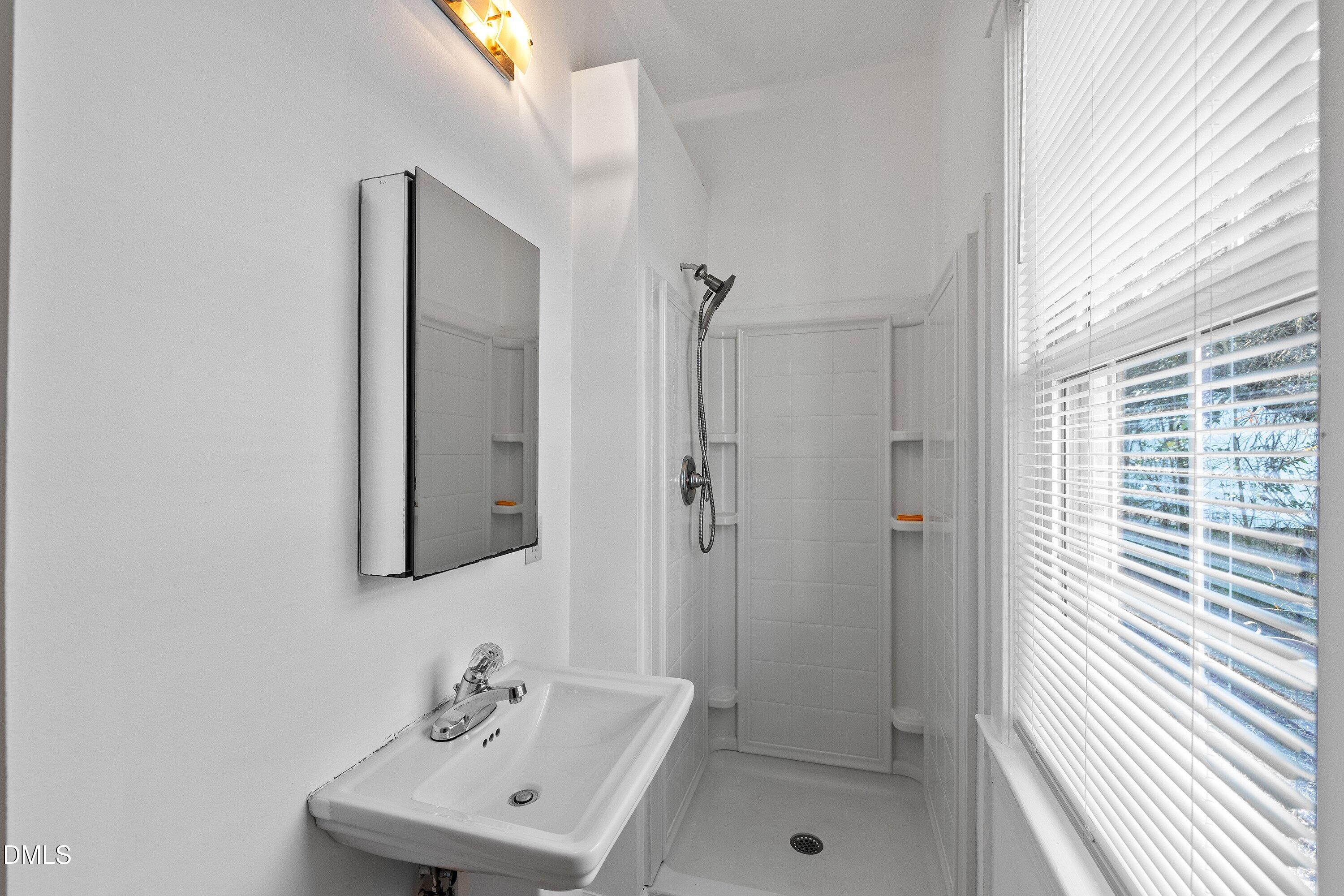 3010 Burrell Place Raleigh, NC 27607 - Photo 28 of 46 a bathroom with a sink a mirror and shower