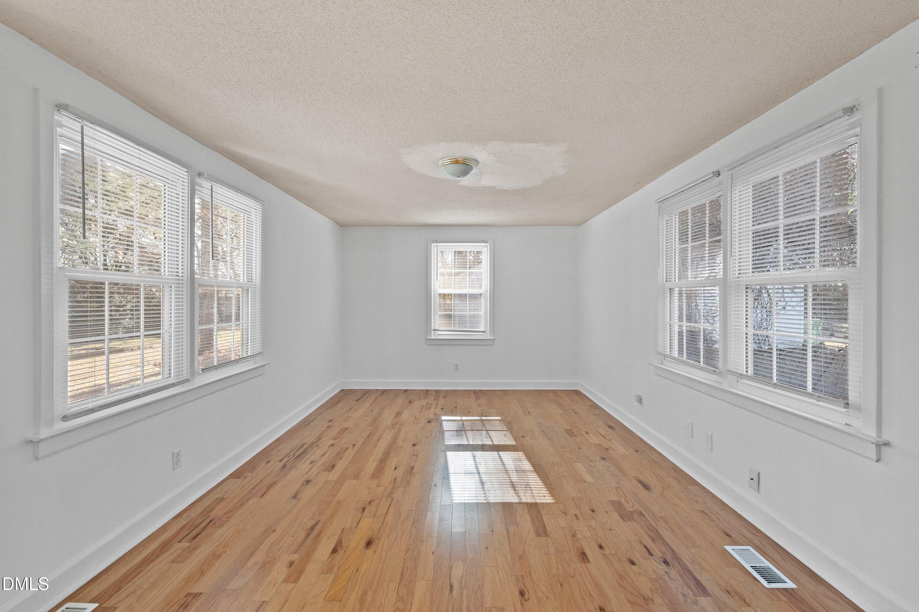 3010 Burrell Place Raleigh, NC 27607 - Photo 29 of 46 a view of an empty room with wooden floor and windows
