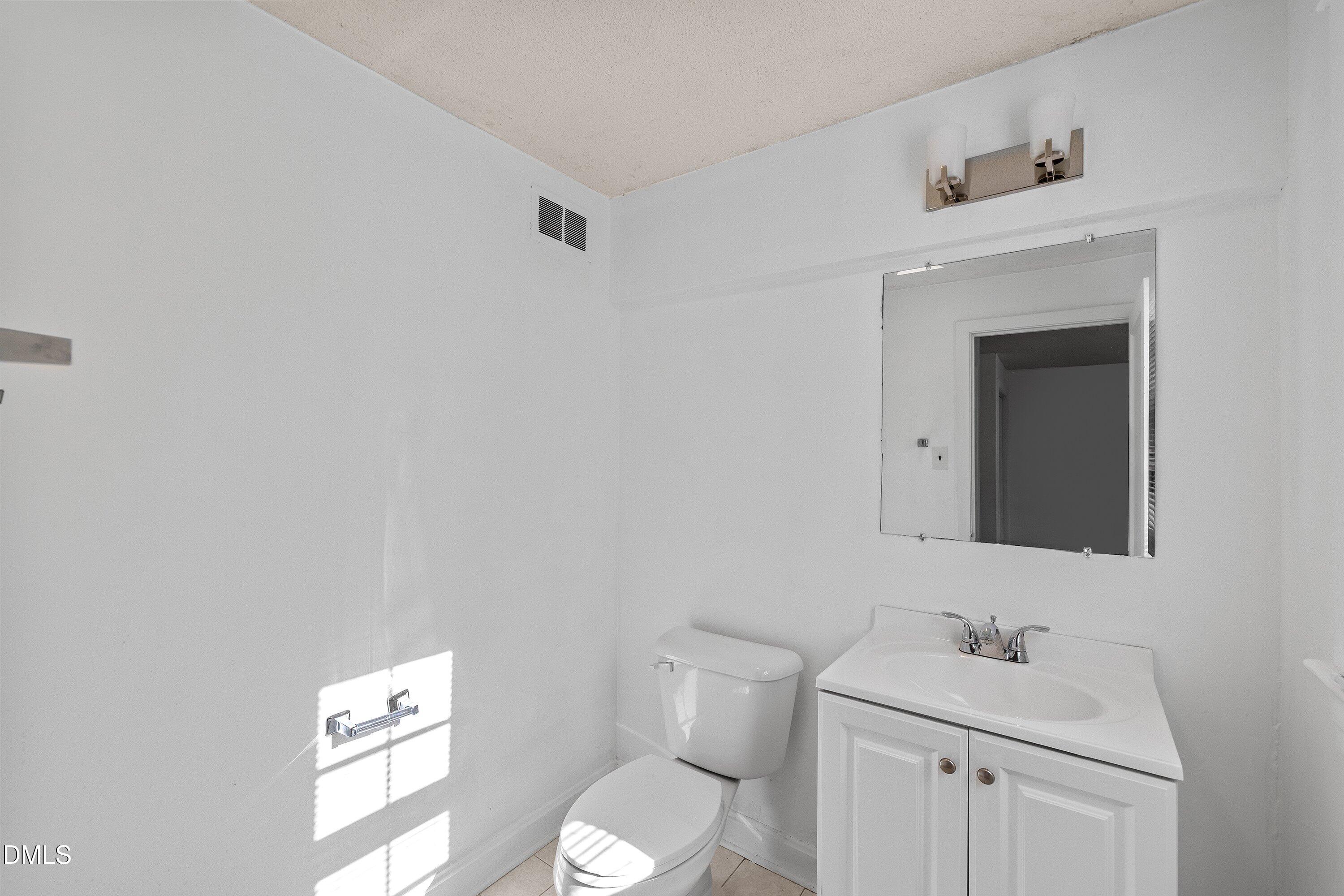 3010 Burrell Place Raleigh, NC 27607 - Photo 32 of 46 a bathroom with a toilet sink vanity and mirror