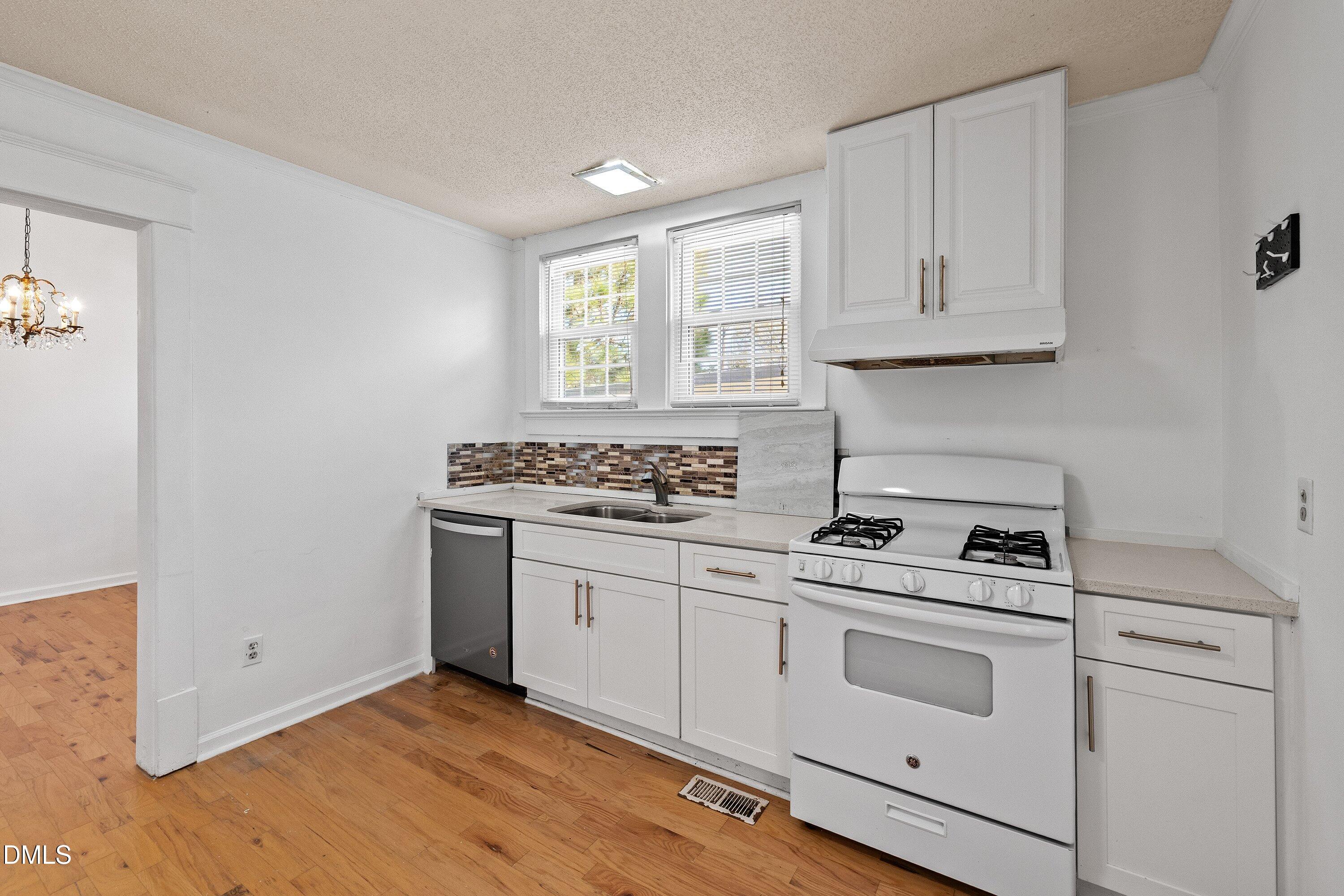 3010 Burrell Place Raleigh, NC 27607 - Photo 37 of 46 a kitchen with granite countertop white cabinets and white appliances