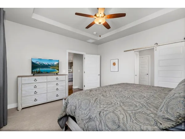 a spacious bedroom with a bed and a chandelier