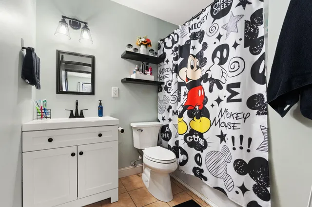 a bathroom with a sink mirror vanity and toilet