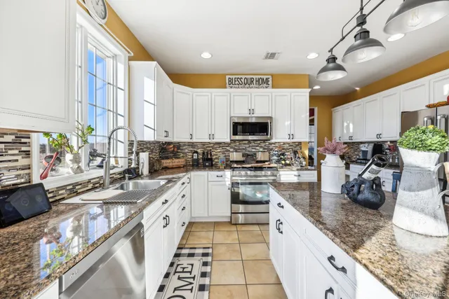 a kitchen with stainless steel appliances granite countertop a sink a stove and cabinets