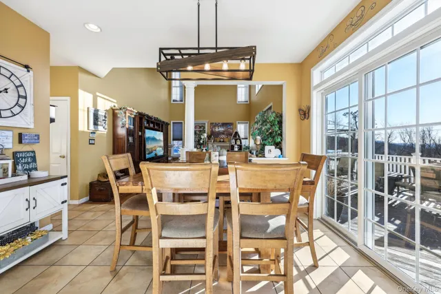a dining room with furniture a chandelier and window
