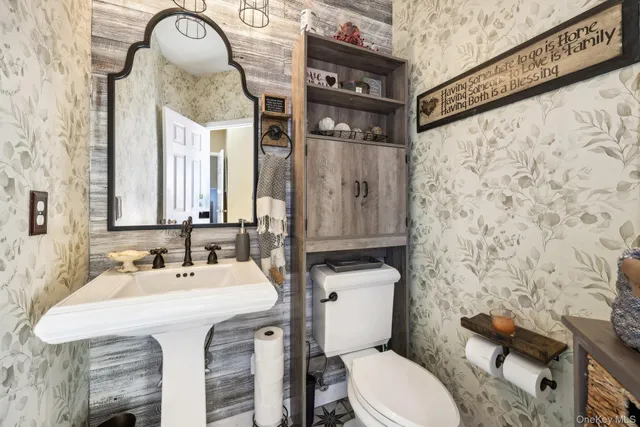 a bathroom with a sink a toilet and shower curtain