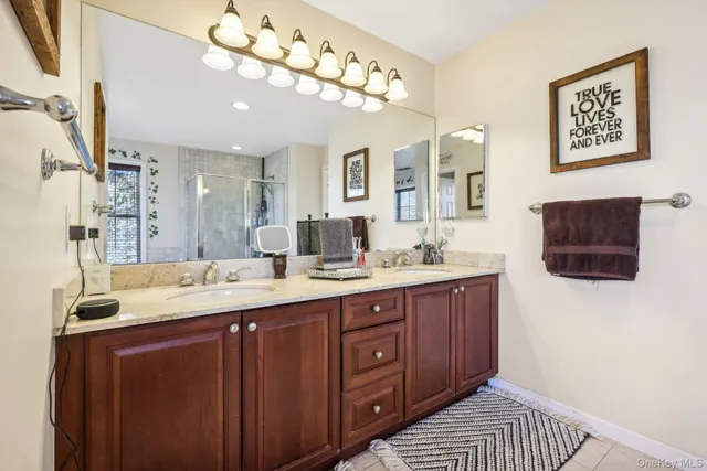 a bathroom with a sink a large mirror and a shower