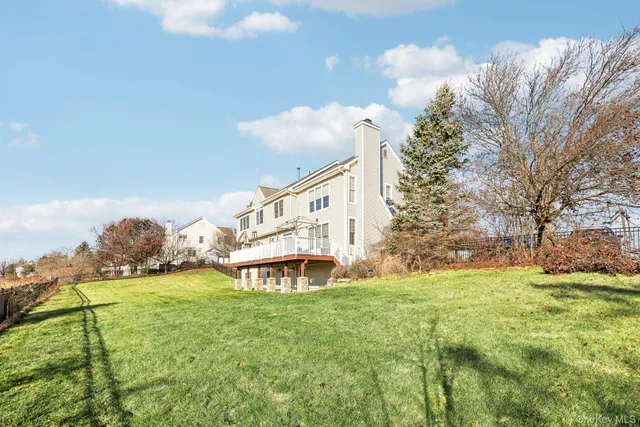 a view of a house with a big yard and large trees
