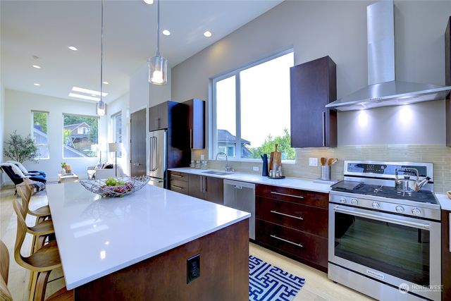 a kitchen with stainless steel appliances a stove a sink cabinets and a dining table