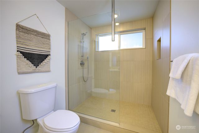 a bathroom with a toilet a sink a mirror and vanity