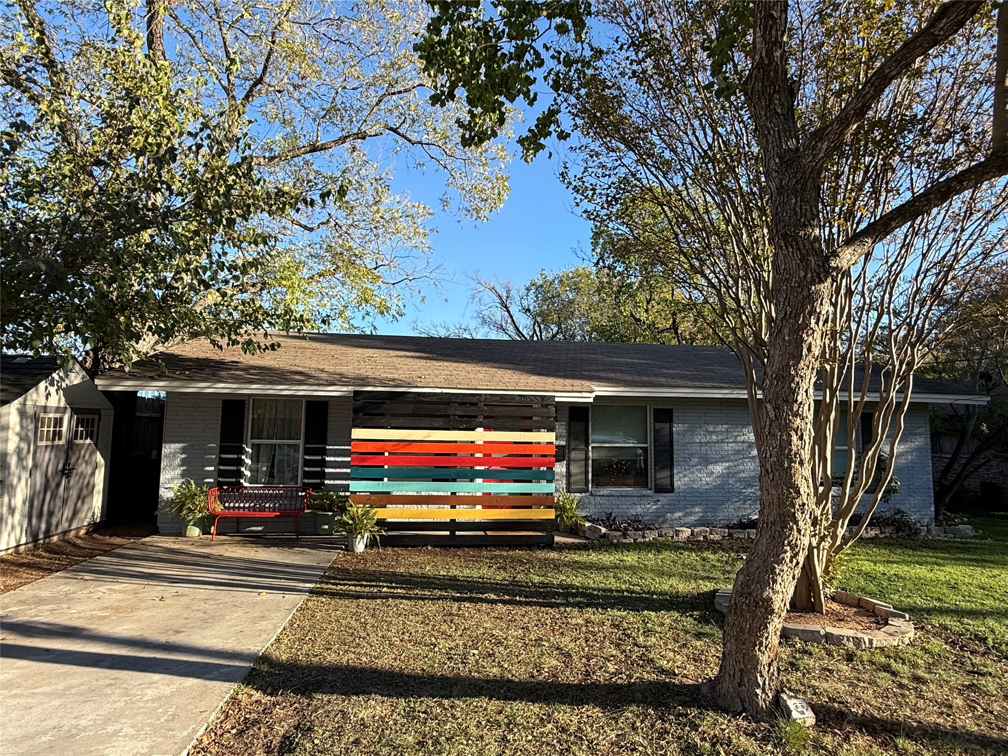 Ranch-style home featuring brick siding, a front lawn, and roof with shingles