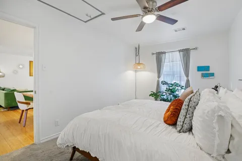 a bedroom with a large bed and a chandelier