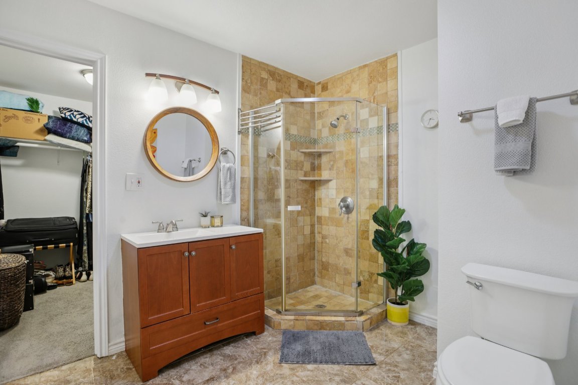 4413 Russell Drive Austin, TX 78704 - Photo 16 of 29 Bathroom with vanity, a shower stall, and a spacious closet
