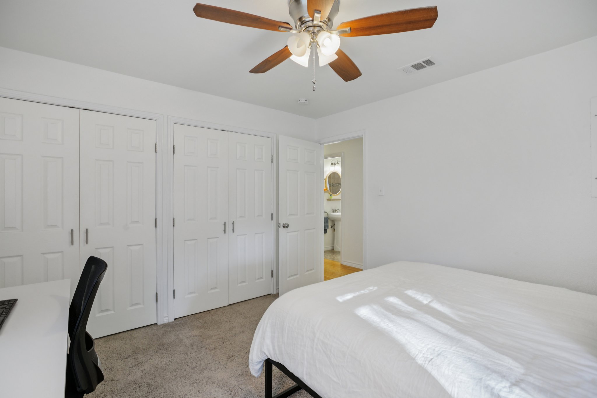 4413 Russell Drive Austin, TX 78704 - Photo 21 of 22 Bedroom featuring two closets, light colored carpet, and ceiling fan