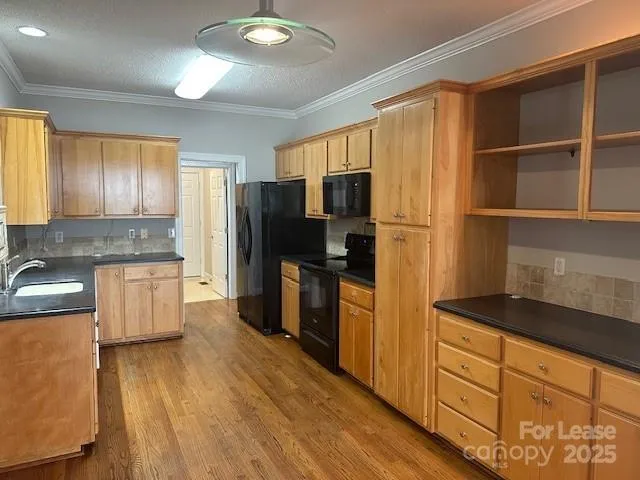 a kitchen with a refrigerator a stove top oven a counter space and wooden floor