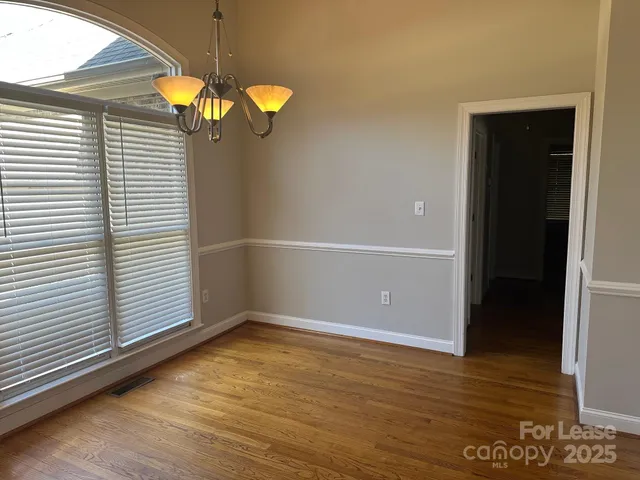 a view of a room with wooden floor and white walls