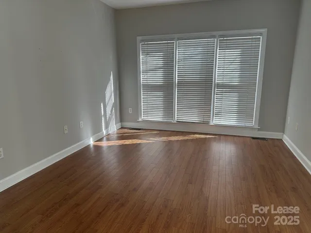 a view of a room with wooden floor and window