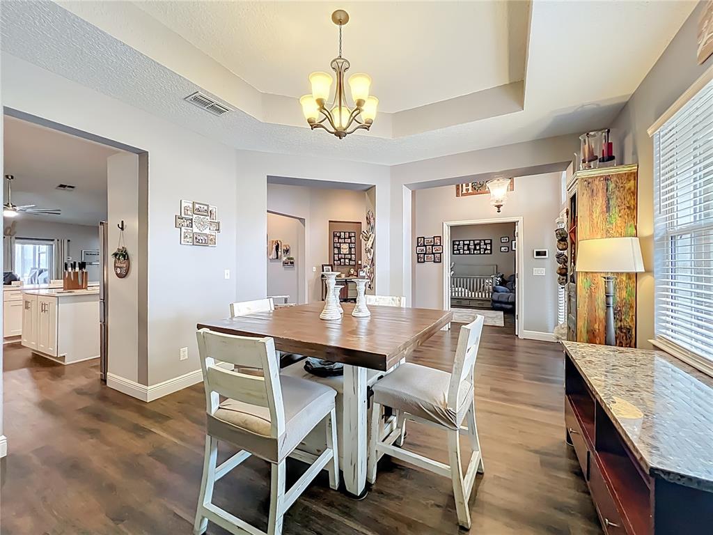 135 Blackstone Creek Road Groveland, FL 34736 - Photo 12 of 62 a view of a dining room with furniture and wooden floor