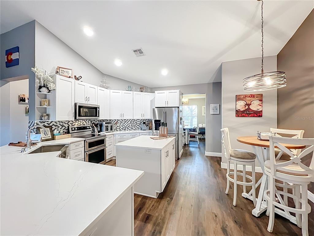 135 Blackstone Creek Road Groveland, FL 34736 - Photo 23 of 62 a large white kitchen with lots of counter space and stainless steel appliances