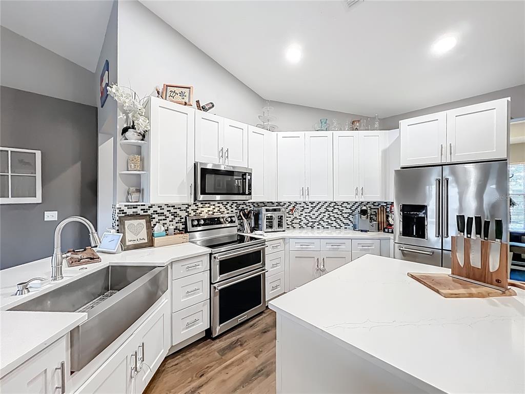 135 Blackstone Creek Road Groveland, FL 34736 - Photo 26 of 62 a kitchen with white cabinets and stainless steel appliances