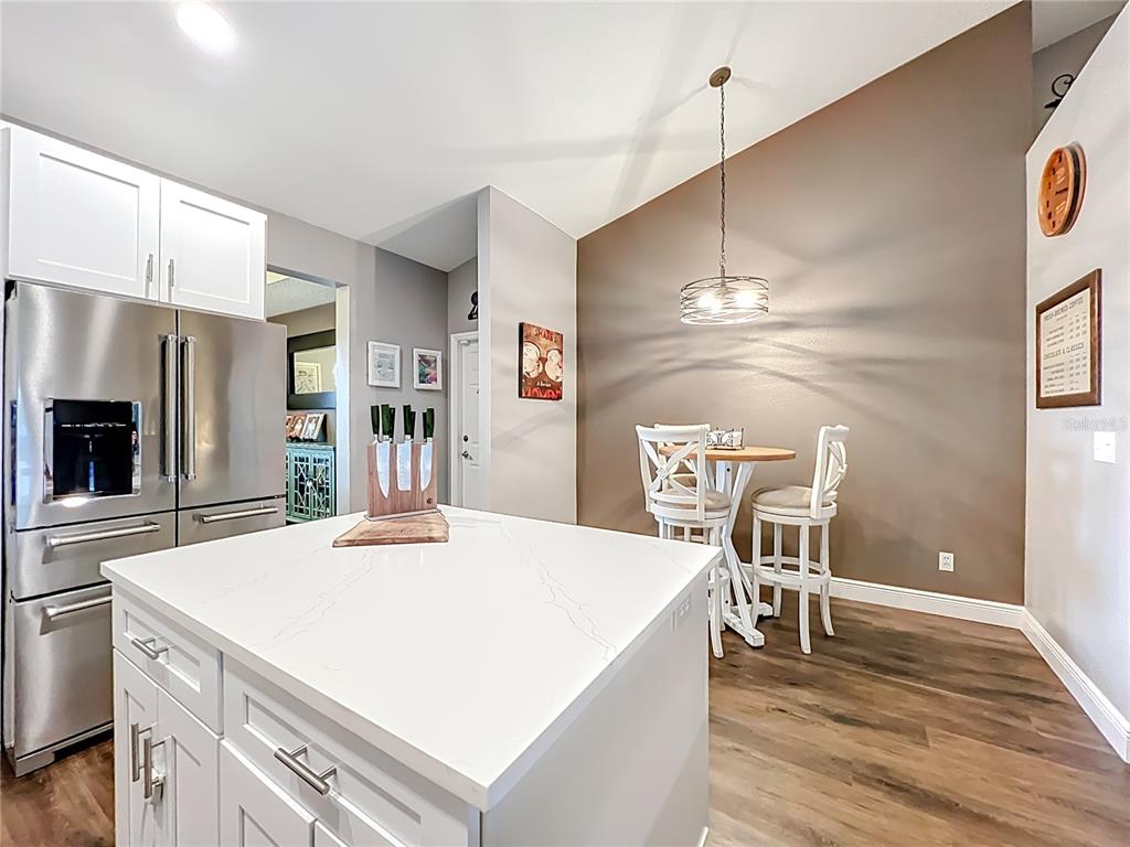 135 Blackstone Creek Road Groveland, FL 34736 - Photo 27 of 62 a kitchen with kitchen island a dining table chairs stainless steel appliances and cabinets