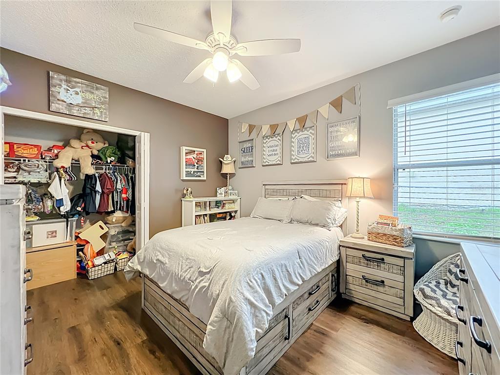 135 Blackstone Creek Road Groveland, FL 34736 - Photo 30 of 62 a bedroom with a bed and a chandelier