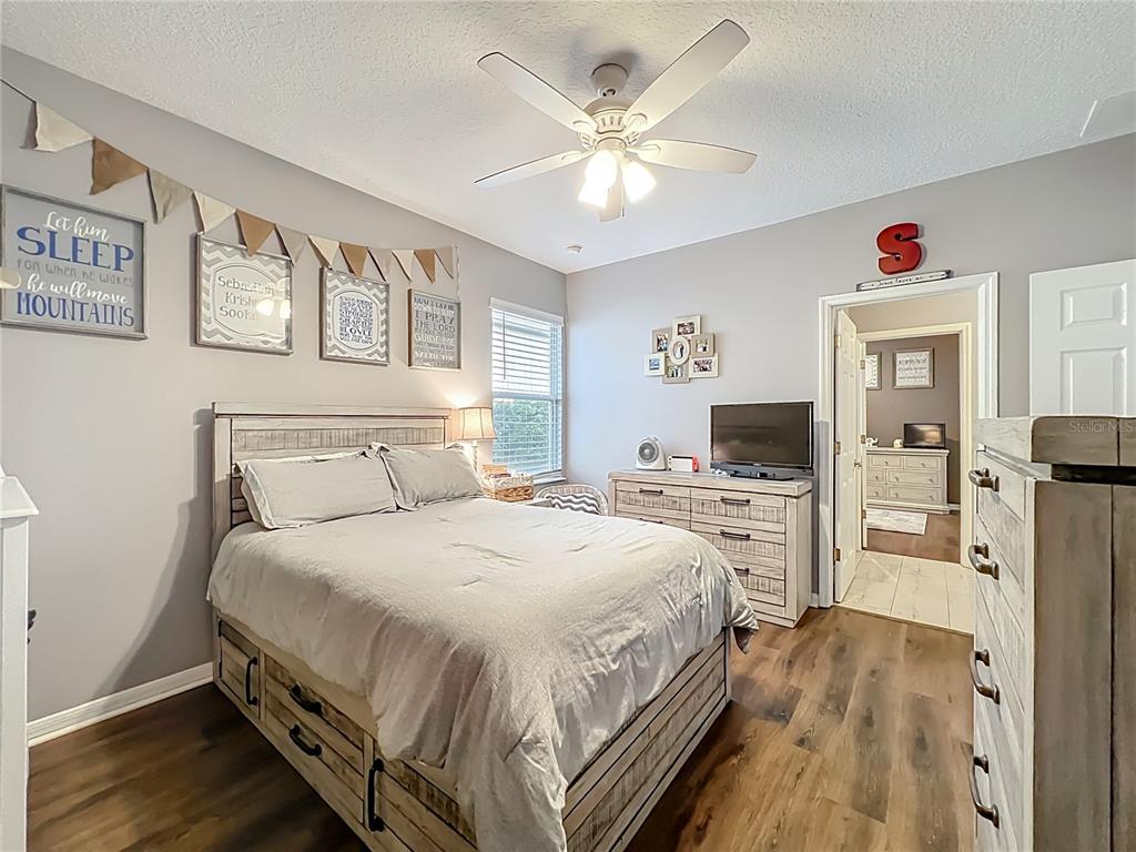 135 Blackstone Creek Road Groveland, FL 34736 - Photo 31 of 62 a spacious bedroom with a bed and a flat screen tv