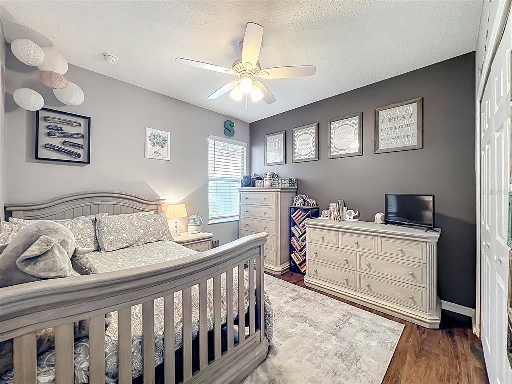 135 Blackstone Creek Road Groveland, FL 34736 - Photo 32 of 62 a bedroom with a bed and wooden floor