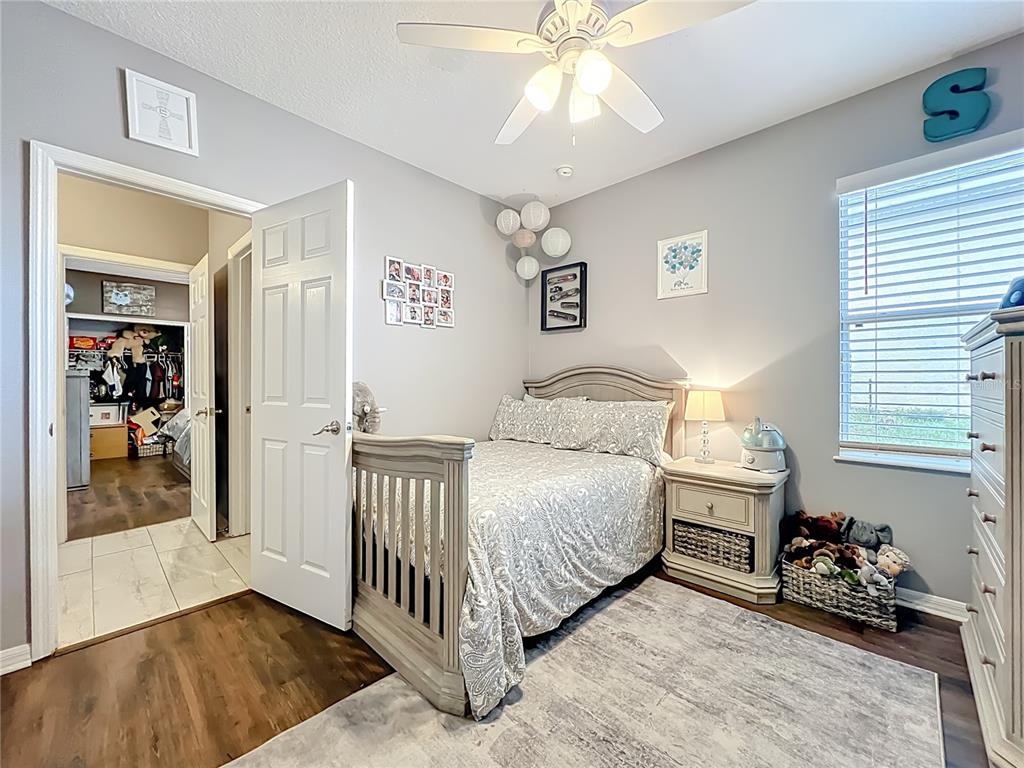 135 Blackstone Creek Road Groveland, FL 34736 - Photo 33 of 62 a bedroom with a bed and a chandelier