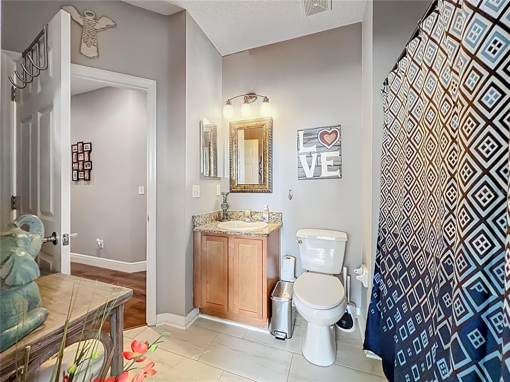 135 Blackstone Creek Road Groveland, FL 34736 - Photo 41 of 62 a bathroom with a toilet a sink and mirror