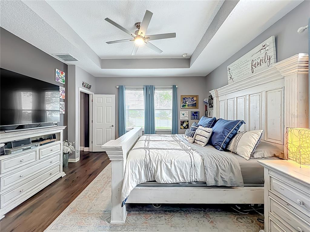 135 Blackstone Creek Road Groveland, FL 34736 - Photo 44 of 62 a bedroom with a large bed and a flat screen tv