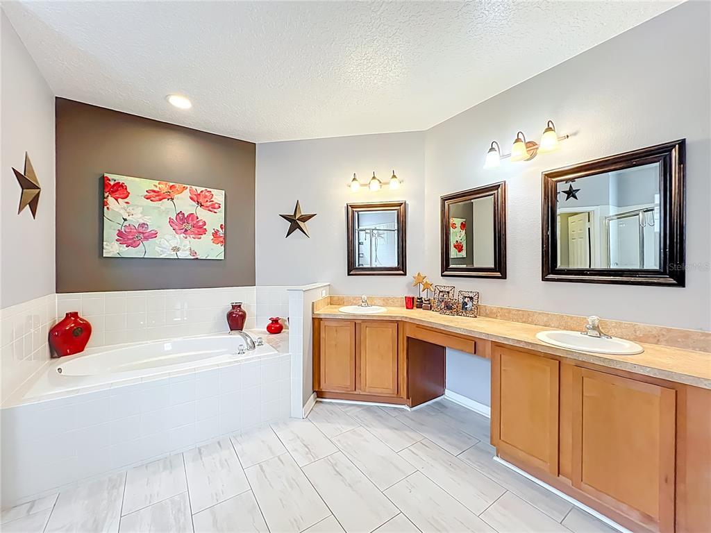 135 Blackstone Creek Road Groveland, FL 34736 - Photo 46 of 62 a white bath tub sitting next to a bathroom sink